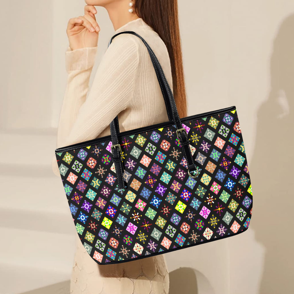 Woman holding a black tote bag with colorful diamond pattern against a neutral background